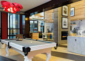 Thumbnail 12 of 47 - a pool table in a living room with a fireplace at Ann Arbor City Club, Ann Arbor