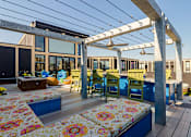 Thumbnail 16 of 47 - a deck with a pergola and a dining area with blue and yellow chairs at Ann Arbor City Club, Ann Arbor, MI