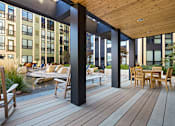 Thumbnail 15 of 47 - a patio with a table and chairs on a deck at Ann Arbor City Club, Ann Arbor, MI 48104