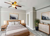 Thumbnail 4 of 66 - A bedroom with a large bed, a ceiling fan, and two framed pictures on the wall.