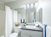 Thumbnail 12 of 17 - a bathroom with a sink toilet and a mirror