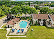 Thumbnail 27 of 29 - A large grassy area with a swimming pool and a building in the background.