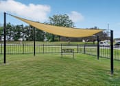 Thumbnail 28 of 29 - A park with a bench and a yellow canopy.