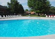 Thumbnail 16 of 18 - a large swimming pool with white chairs around it