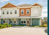 Thumbnail 1 of 37 - A two-story building with a red and white exterior and a brown roof.