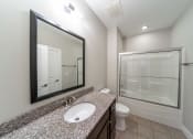 Thumbnail 20 of 22 - Bathroom with large mirror. Updated granite vanity with sink, toilet, and shower tub combo.