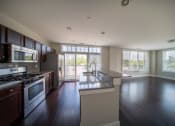 Thumbnail 12 of 22 - Modern kitchen with large windows, stainless steal appliances, and a large kitchen island at the Residences of Creekside.