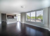 Thumbnail 11 of 22 - Kitchen, and living area with dark hardwood like floors and large picture windows at the Residences of  Creekside.