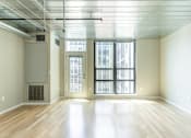 Thumbnail 5 of 47 - an empty living room with large windows and wood floors at Ann Arbor City Club, Ann Arbor, MI 48104