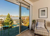 Thumbnail 7 of 20 - a balcony with a chair and a sliding glass door at Village Club of Royal Oak, Royal Oak, MI