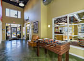 Thumbnail 13 of 20 - a game room with a foosball table and a chair at Village Club of Royal Oak, Royal Oak, MI 48067