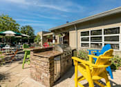 Thumbnail 11 of 20 - a backyard with a barbecue grill and chairs at Village Club of Royal Oak, Royal Oak, 48067