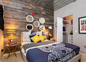 Thumbnail 3 of 47 - a bedroom with a bed and a wall with various plates on it at Ann Arbor City Club, Ann Arbor, 48104