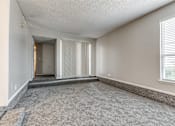 Thumbnail 41 of 50 - A room with a carpeted floor and a window with blinds.