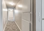 Thumbnail 50 of 50 - A long hallway with a light on the ceiling and a door on the right.