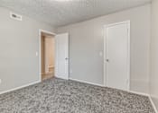 Thumbnail 49 of 50 - A room with two doors and a carpeted floor.
