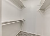 Thumbnail 46 of 50 - A white closet with shelves and a carpeted floor.