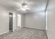 Thumbnail 42 of 50 - A room with a ceiling fan and carpeted floor.
