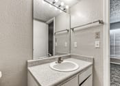 Thumbnail 45 of 50 - A bathroom with a sink and mirror.