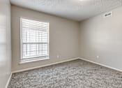 Thumbnail 32 of 50 - A room with a window and carpeted floor.