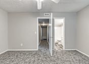 Thumbnail 25 of 50 - A room with a carpeted floor and a doorway leading to another room.