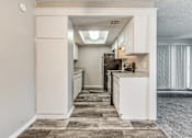 Thumbnail 21 of 50 - A kitchen with white cabinets and a tiled floor.