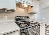 Thumbnail 19 of 50 - A modern kitchen with a stove top oven.