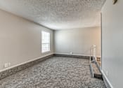 Thumbnail 17 of 50 - A room with a carpeted floor and a window with blinds.