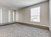 Thumbnail 14 of 50 - A room with a carpeted floor and a window with blinds.