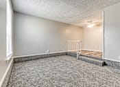 Thumbnail 12 of 50 - A room with a grey carpet and a white wall.