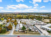 Thumbnail 6 of 50 - A red car is driving on a road in a suburban area.