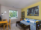 Thumbnail 6 of 26 - A room with a bed, desk, and chair.