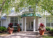 Thumbnail 16 of 26 - a white building with potted plants in front of it at Village Club of Farmington Hills, Farmington Hills, 48331