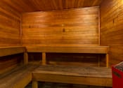 Thumbnail 23 of 26 - A wooden sauna with benches and a door.