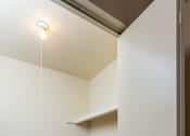 Thumbnail 7 of 26 - A small, empty room with a carpeted floor and a single light fixture on the ceiling.