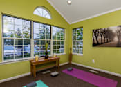 Thumbnail 24 of 26 - A room with a green wall and a purple yoga mat on the floor.