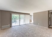 Thumbnail 4 of 16 - Living room with sliding glass door, gray walls, and plush carpeting