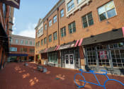 Thumbnail 22 of 22 - Brick storefront with benches in front at The Residences of Creekside.
