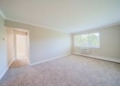 Thumbnail 1 of 17 - Living room with window and carpeting leading to hallway