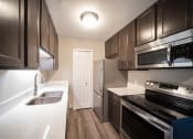 Thumbnail 5 of 17 - Renovated kitchen with stainless appliances and quartz countertops