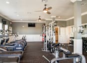 Thumbnail 24 of 37 - A gym with treadmills, weights, and exercise equipment.