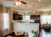 Thumbnail 37 of 37 - A kitchen with a brown couch and a ceiling fan.