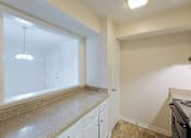 Thumbnail 24 of 47 - A kitchen with white cabinets and a granite countertop.