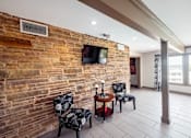 Thumbnail 12 of 47 - A living room with a brick wall and a television mounted on it.