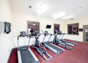 Thumbnail 22 of 47 - A gym with treadmills and exercise bikes.