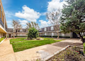 Thumbnail 5 of 47 - A sunny day at a residential complex with a clear blue sky.