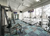 Thumbnail 16 of 47 - a gym with treadmills and other exercise equipment and a large window