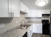 Thumbnail 31 of 47 - a kitchen with white cabinets and granite counter tops and a sink