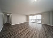 Thumbnail 33 of 47 - an empty living room with wood flooring and a large window