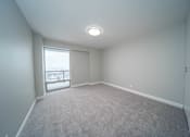 Thumbnail 36 of 47 - an empty living room with a window and carpet